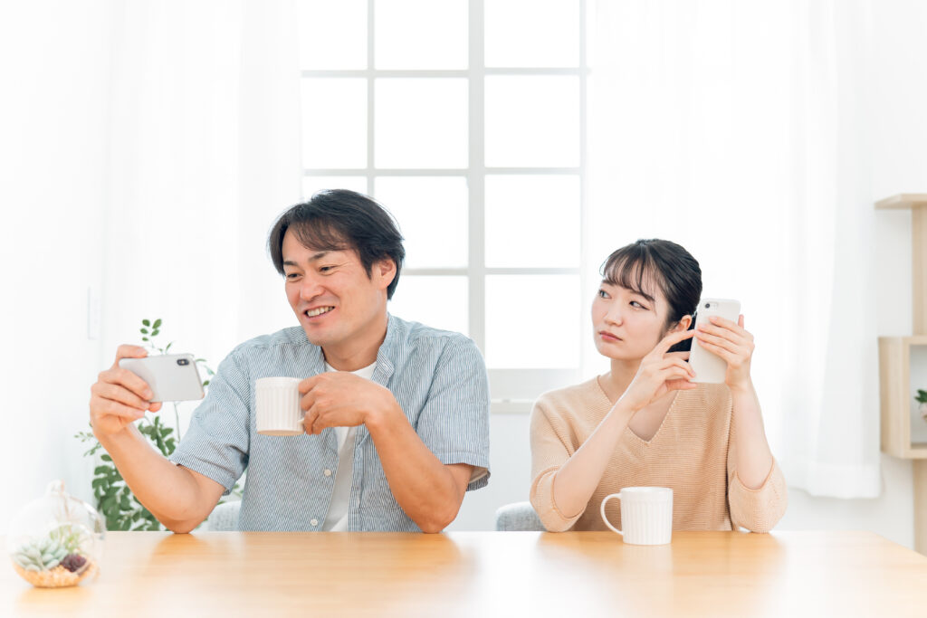 スマホを見る男性とにらむ女性