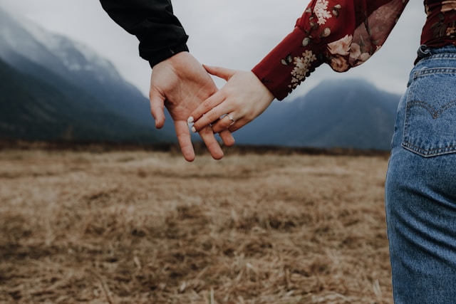 草原で手を繋ぐ男女